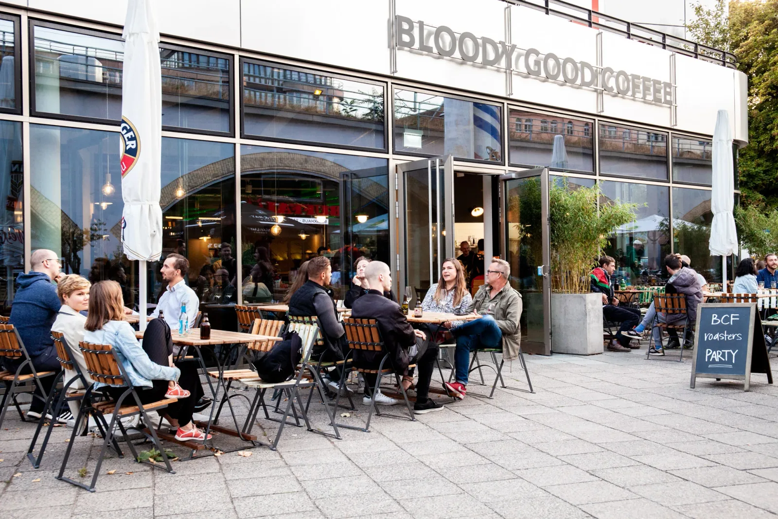 outdoor café seating at bloody good coffee with patrons enjoying beverages and conversation., 19grams chaussee, berlin