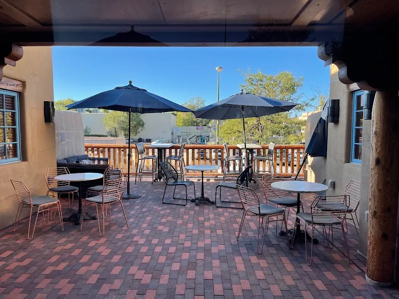 outdoor patio with umbrellas, tables, chairs, and clear blue sky., 35 north coffee, santa fe