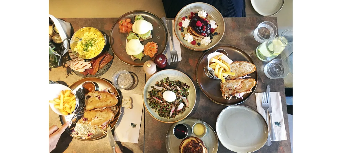overhead view of shared brunch spread with eggs, pastries, pancakes, and fresh berries., 46 & 3rd - forty six and third, pari