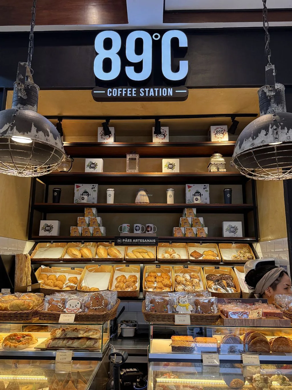 coffee station storefront displaying pastries, breads, and beverages with industrial lighting., 89ºc coffee station, são paul