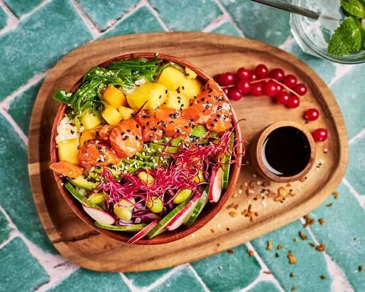 colorful vegetable bowl with sauce, cherry tomatoes, and garnish on wooden platter., acai and you - maubeuge | all week brunc