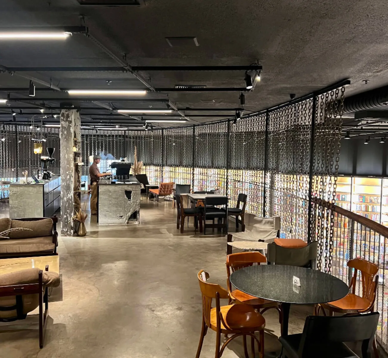 industrial loft space with concrete floors, metal railings, and mid-century modern furniture throughout., acervo café - casa 