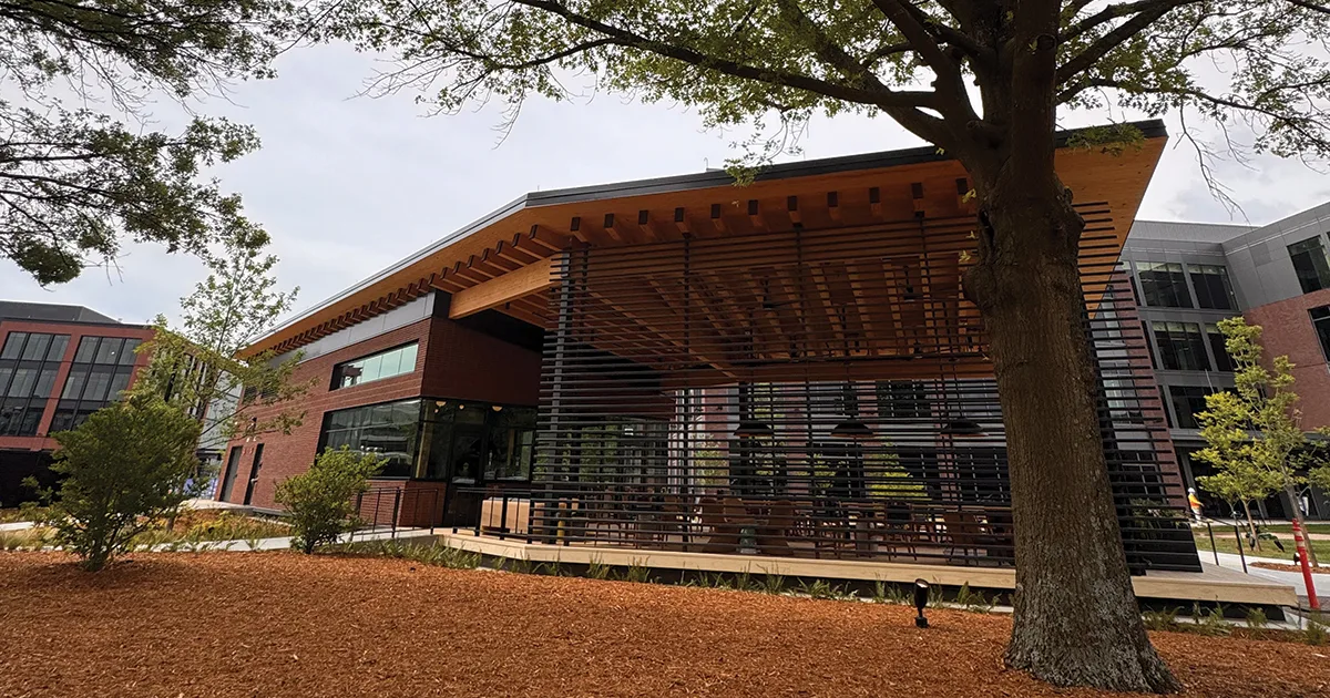 modern brick building with wooden pergola and slatted screens, surrounded by trees., airship coffee at 5th street, bentonvill