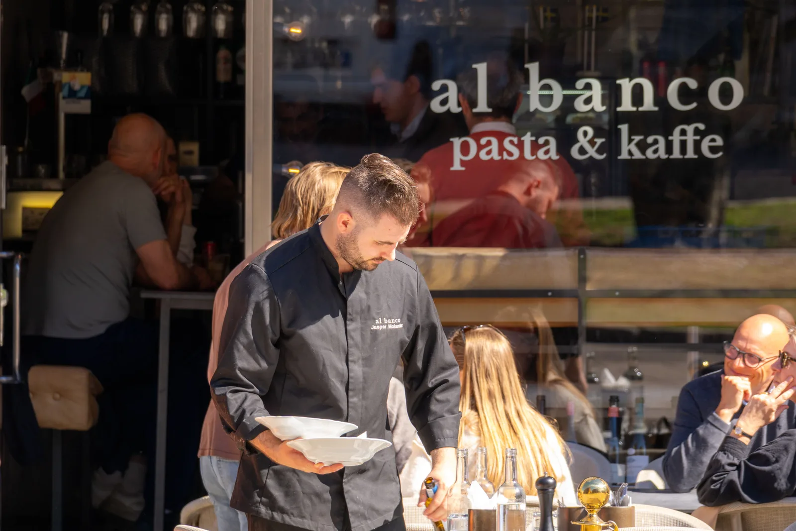waiter serving plates at al banco pasta and kaffe restaurant during evening service., al banco, gothenburg