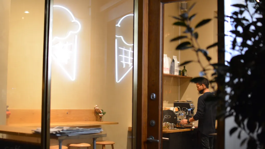 modern cafe interior with neon signs, barista, and minimalist wooden counter design., alice, copenhagen