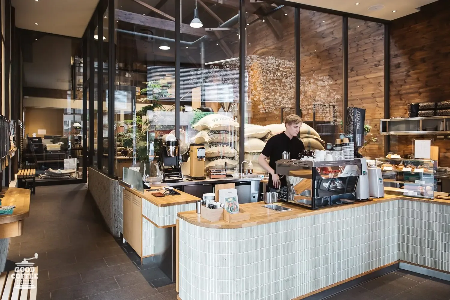 modern coffee shop interior with barista at counter, large windows, wooden accent wall., allpress espresso tokyo roastery & c