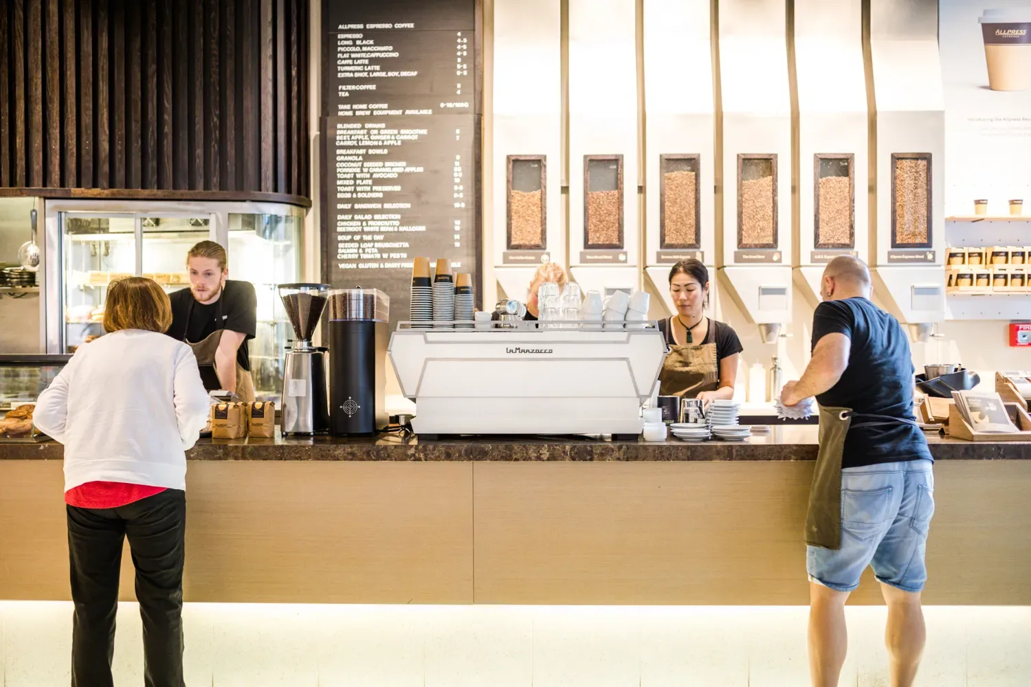 modern coffee shop counter with staff serving customers during daytime rush., allpress roastery auckland, auckland