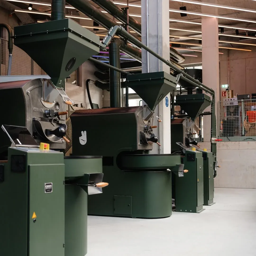 industrial coffee roasting equipment with green machines and overhead piping system., alrighty roastery & coffee shop, munich