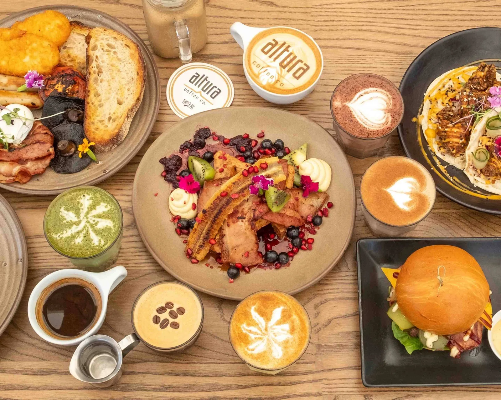 overhead view of brunch spread with coffee drinks and plated dishes at altua cafe., altura coffee company, auckland