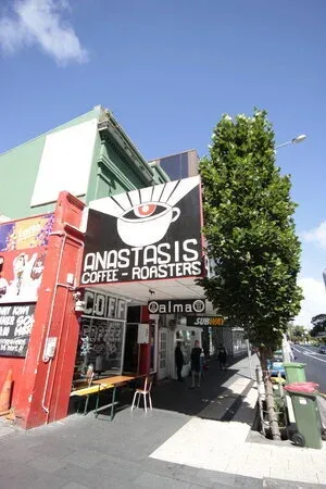 colorful corner coffee shop with large eye logo and ivy-covered wall., anastasis coffee roasters, auckland