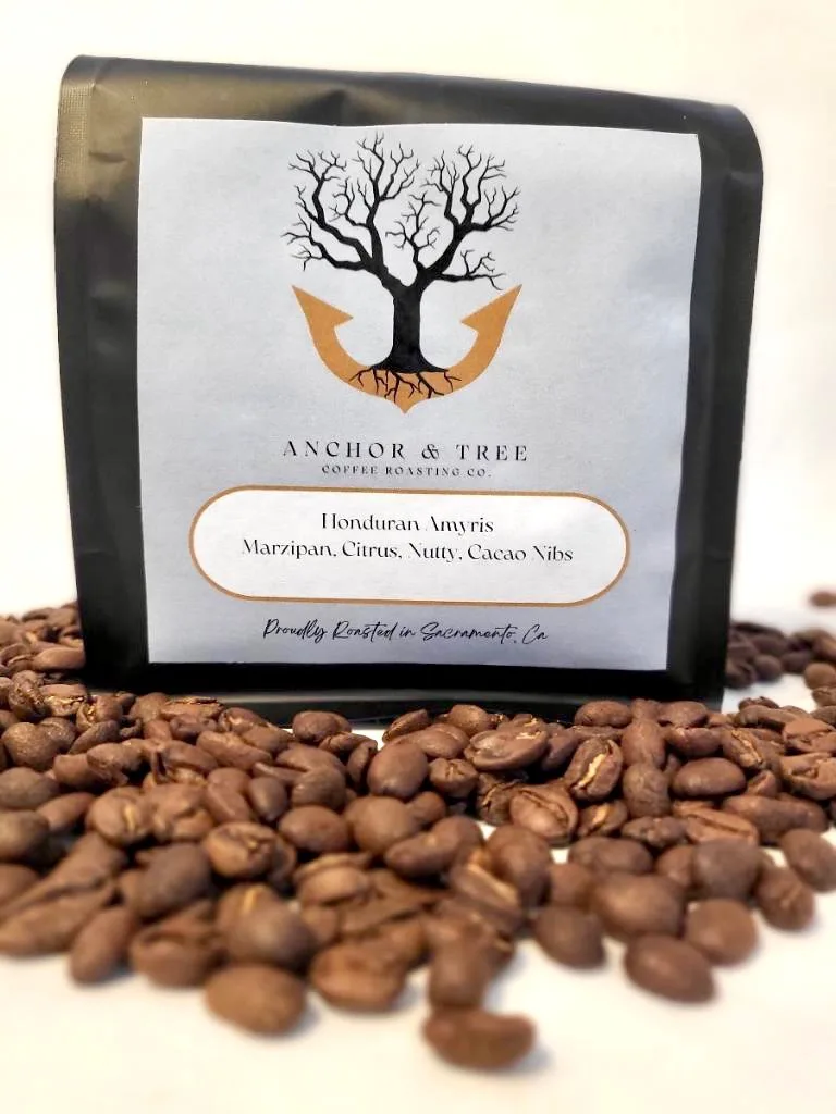 anchor & tree coffee bag with honduran amaris beans scattered in foreground., anchor and tree coffee roasting, sacramento