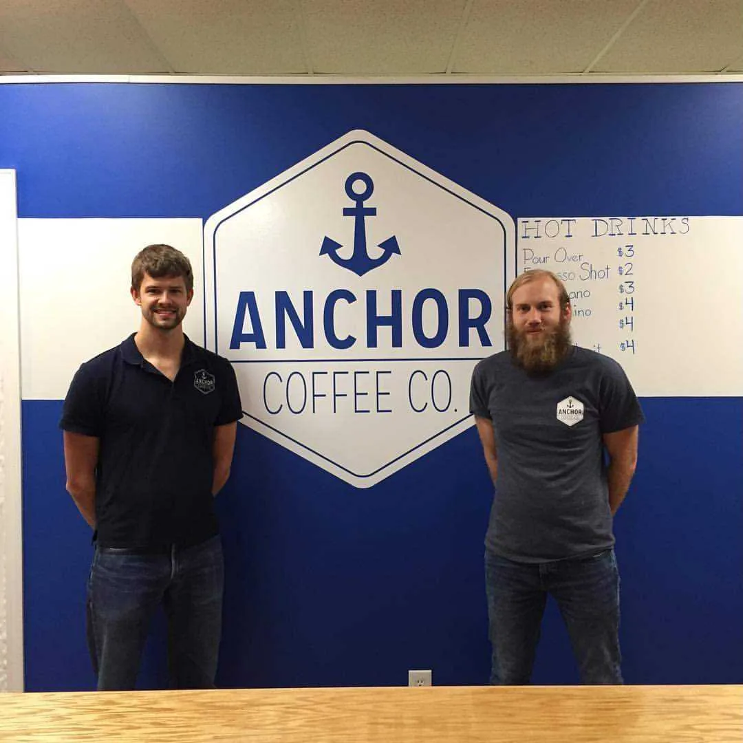two men standing in front of anchor coffee co. branded wall signage with nautical theme., anchor coffee co, north wilkesboro