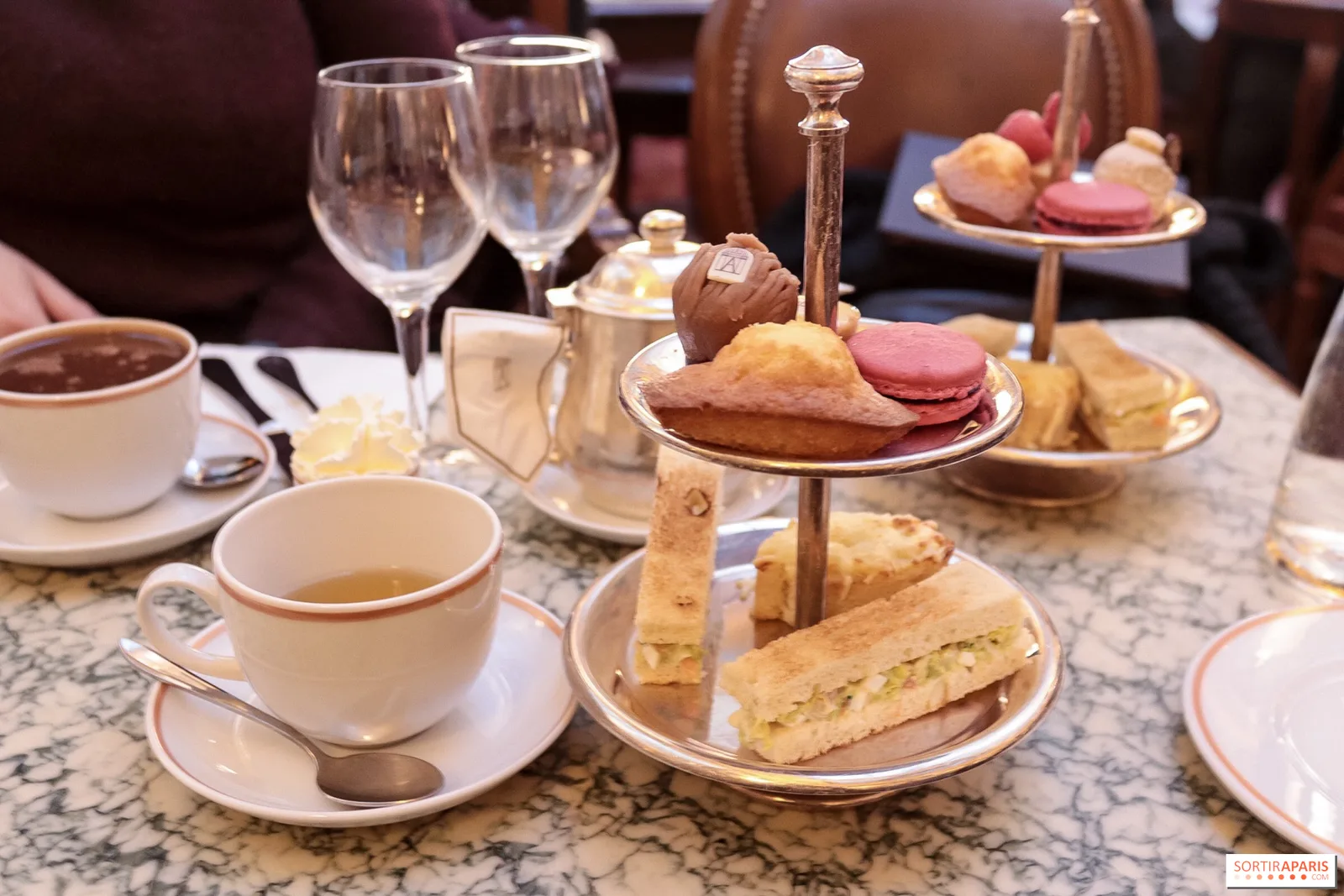 elegant afternoon tea service with pastries, macarons, and china on marble table., angelina, paris