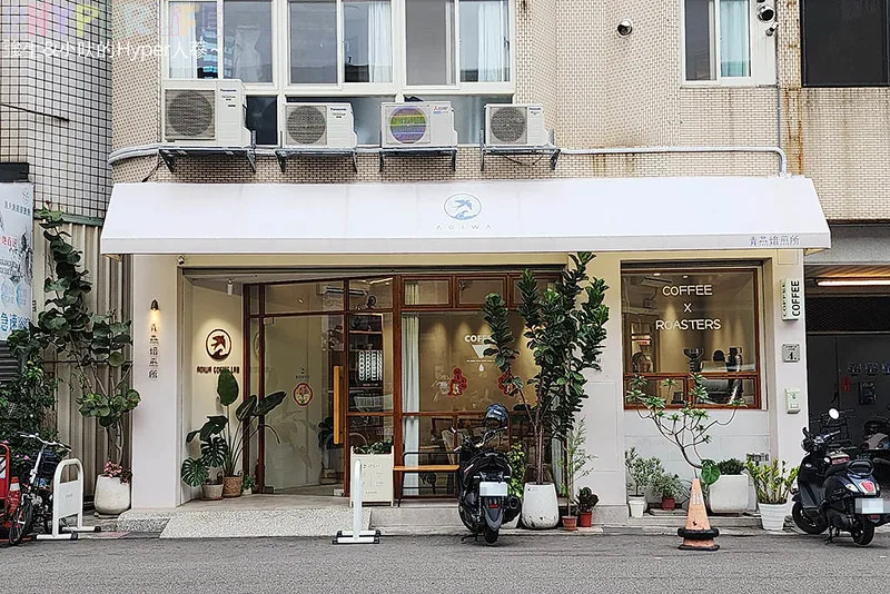 minimalist white coffee shop storefront with plants and parked scooters., 青燕焙煎所aoiwa coffee - 賣牛肉麵的咖啡館, taichung
