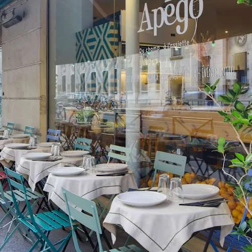 elegant restaurant storefront with turquoise chairs and white-clothed dining tables., apégo, paris