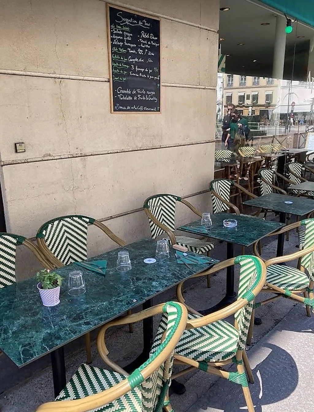 parisian café terrace with green striped chairs and marble-topped tables., apégo, paris