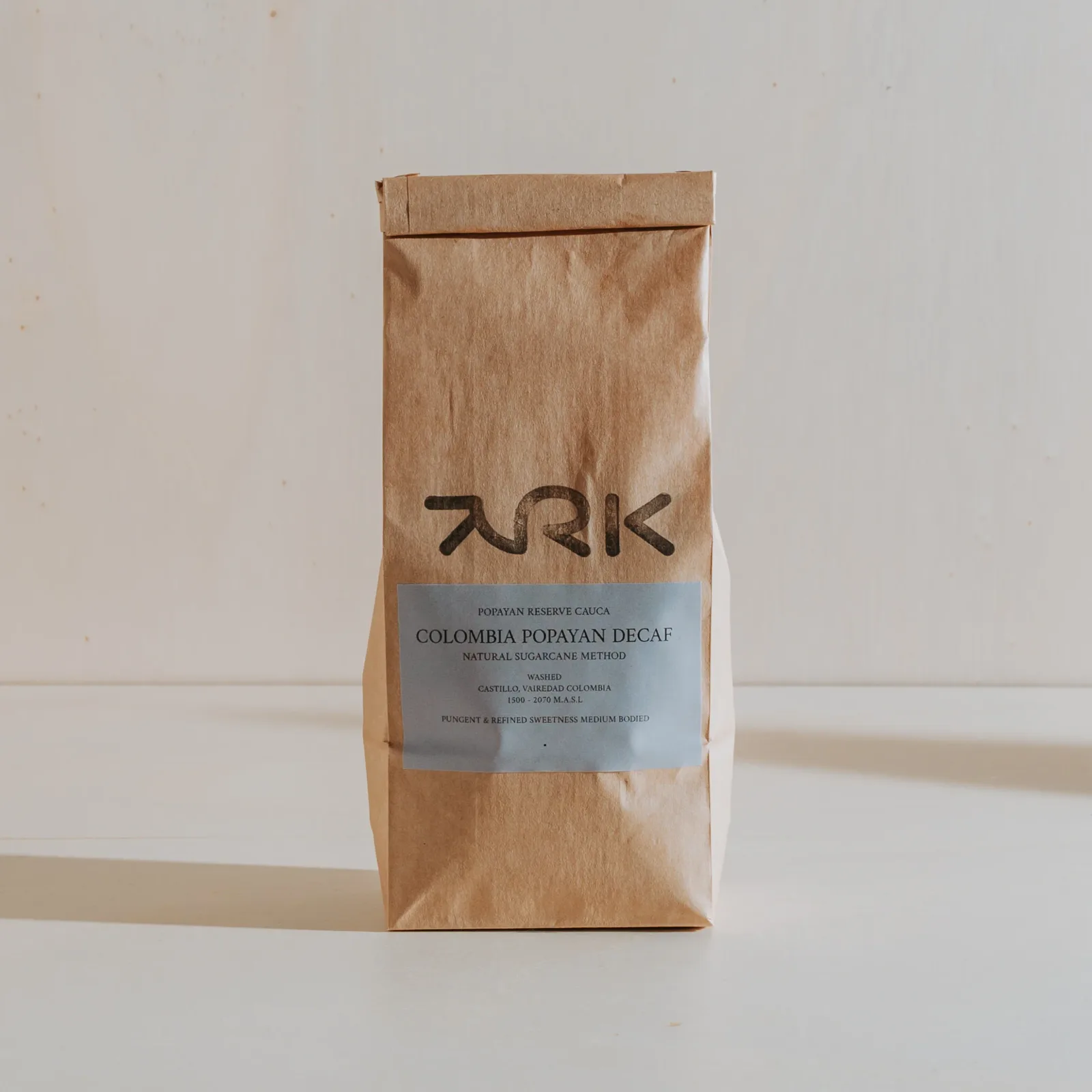 brown kraft paper coffee bag with gray label on white surface., ark coffee company, auckland
