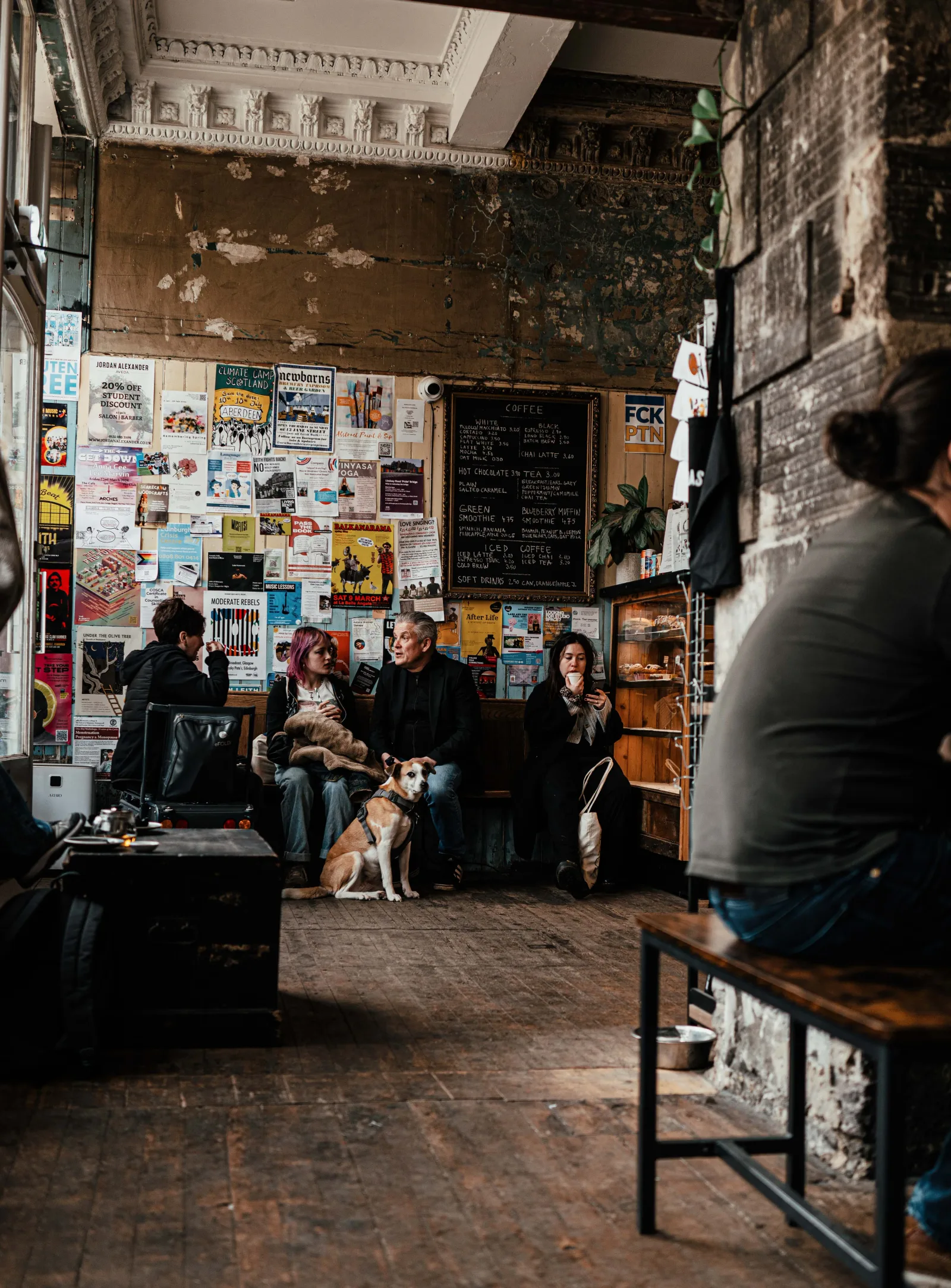 cozy café interior with patrons, dog, posters, and blackboard menu., artisan roast bruntsfield, edinburgh