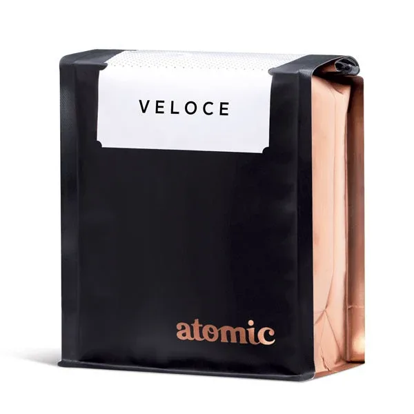 black and copper tape dispenser branded "atomic" with "veloce" label visible., atomic coffee roasters, auckland