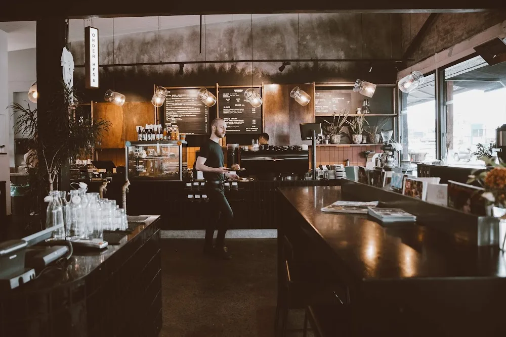modern coffee shop interior with barista, dark counters, and pendant lighting., atomic coffee roasters, auckland