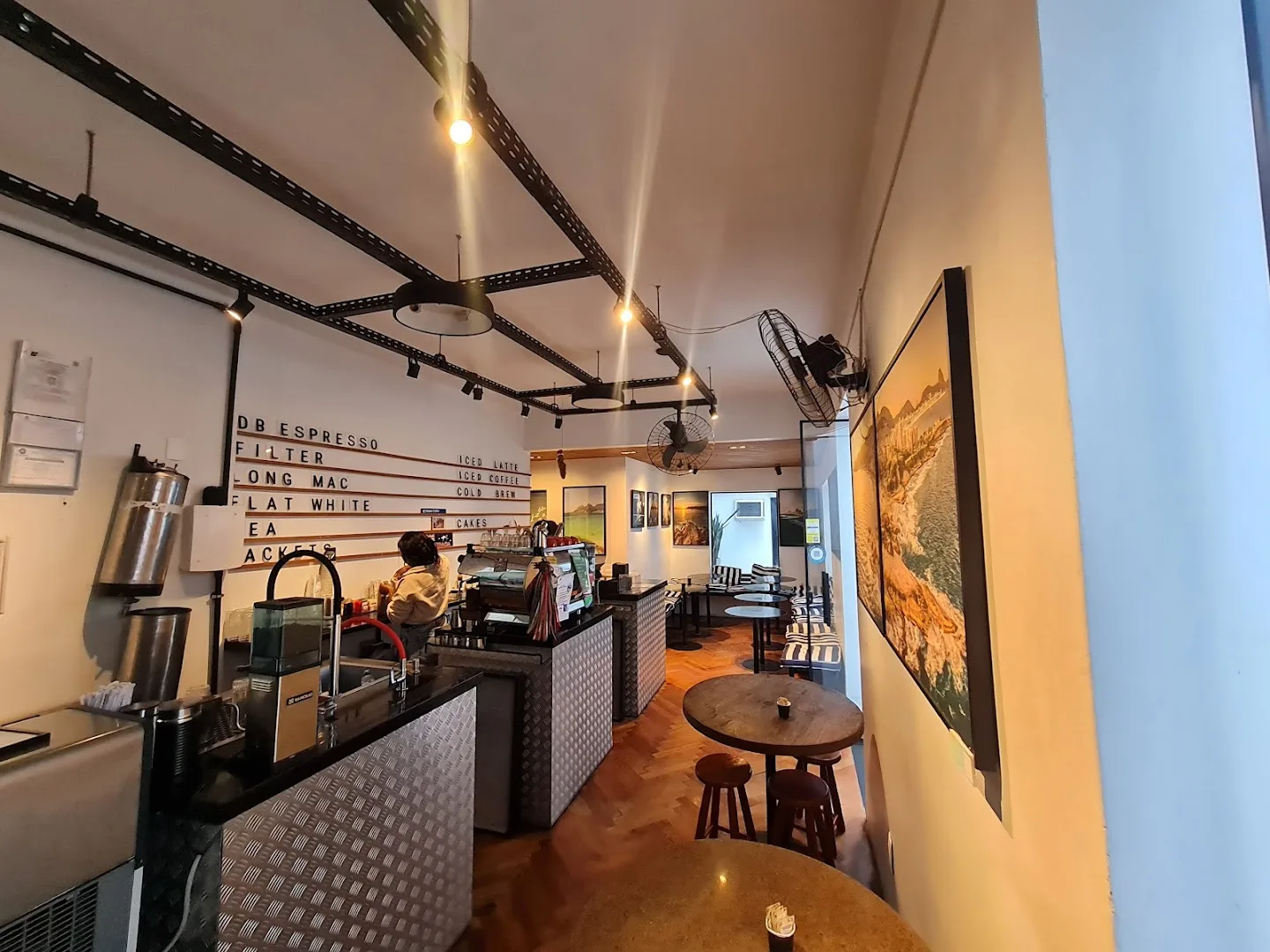 modern coffee shop interior with menu board, counter seating, and warm lighting throughout., aussie coffee (hidden down a lon