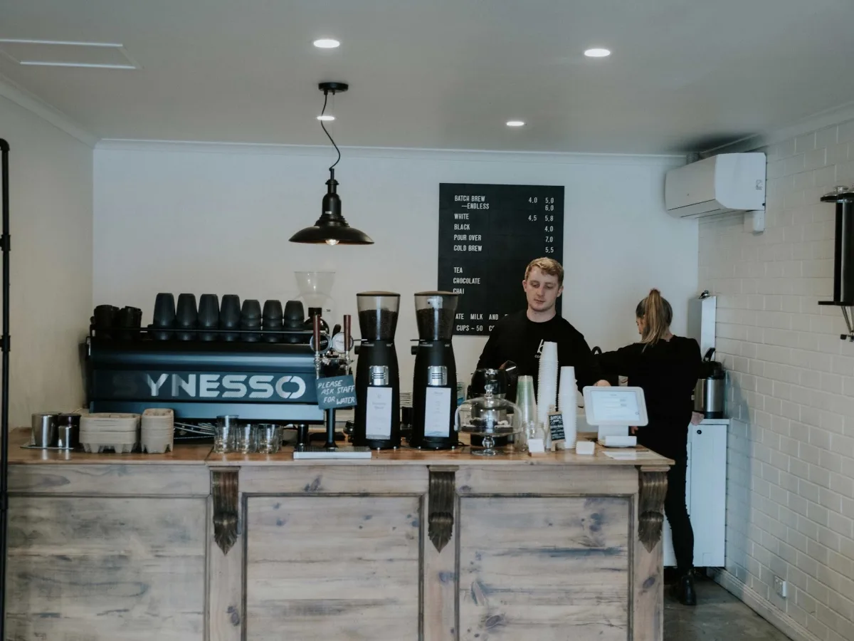 modern coffee shop interior with two baristas behind wooden counter serving drinks., b3 coffee, blackwood