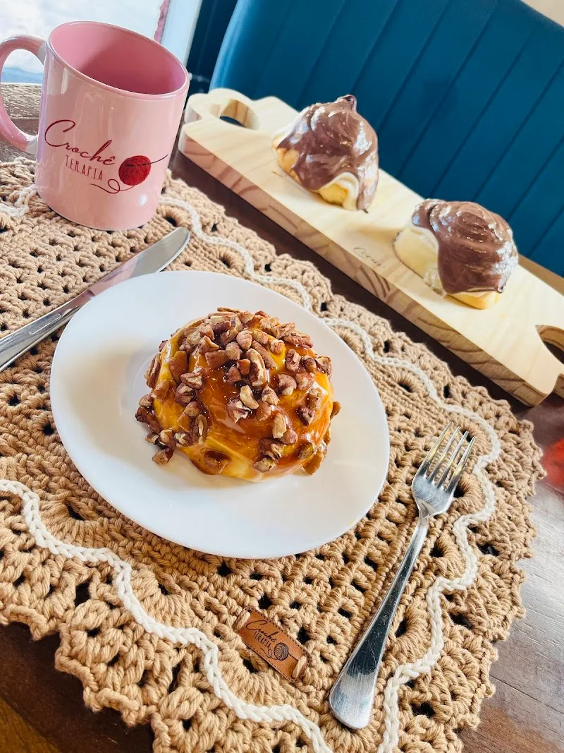 pink mug, pastries with chocolate and nuts on wooden board, plated dessert on crochet placemat., bakebun bela vista, são paul