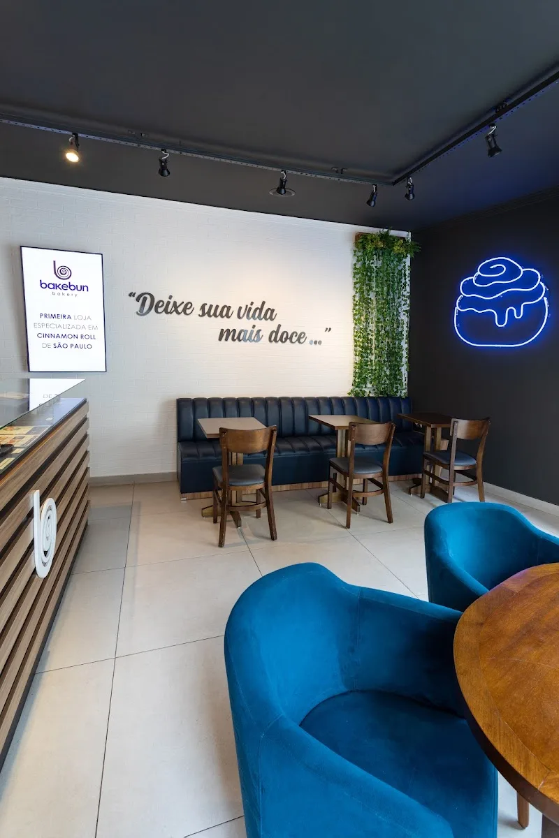 modern bakery interior with blue neon cupcake sign and portuguese tagline., bakebun bela vista, são paulo