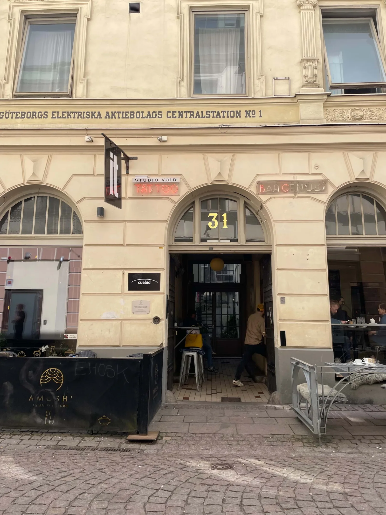 historic swedish building facade with arched windows and ground floor businesses., bar centro, gothenburg