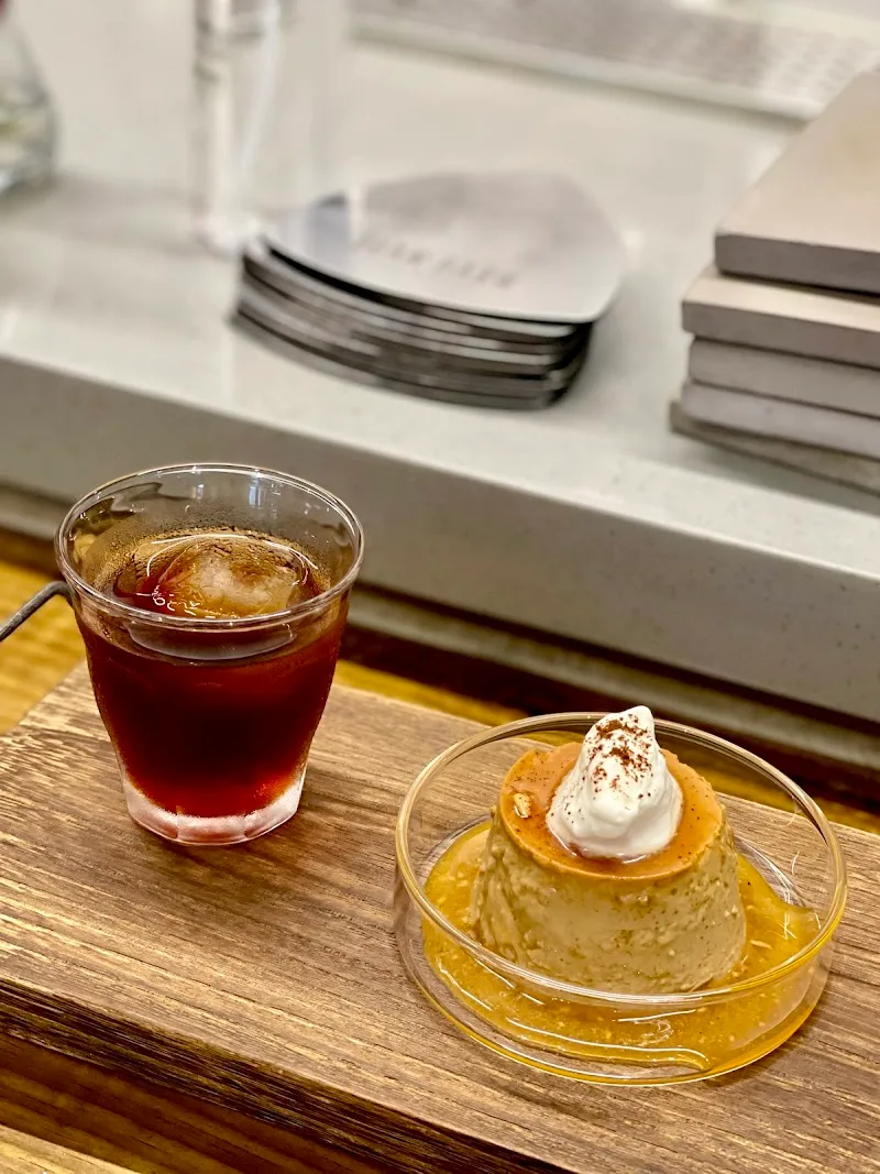 dessert plated with whipped cream beside iced cola beverage on wooden table., bean barn 豆荒良倉 (最後點餐5pm), taipei