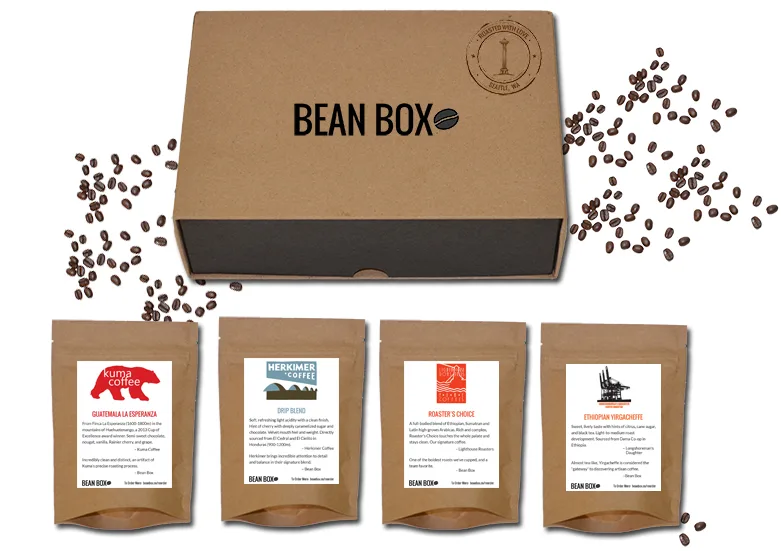 bean box subscription set with four craft coffee bags displayed below cardboard shipping box., bean box, seattle