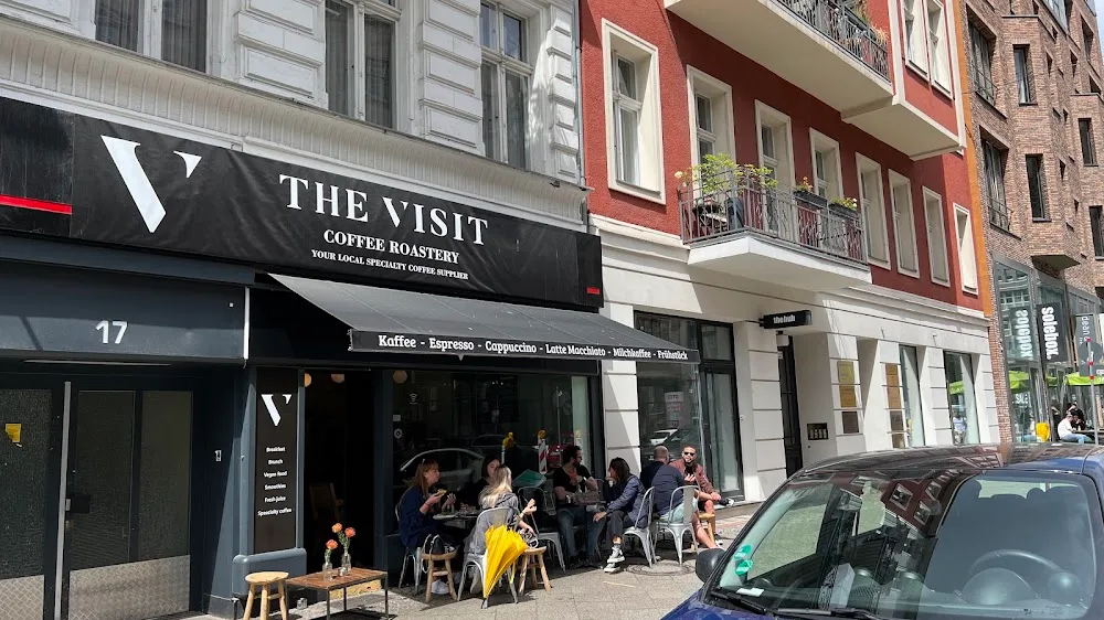 busy street-level coffee shop with outdoor seating and pedestrian foot traffic., bean house, berlin
