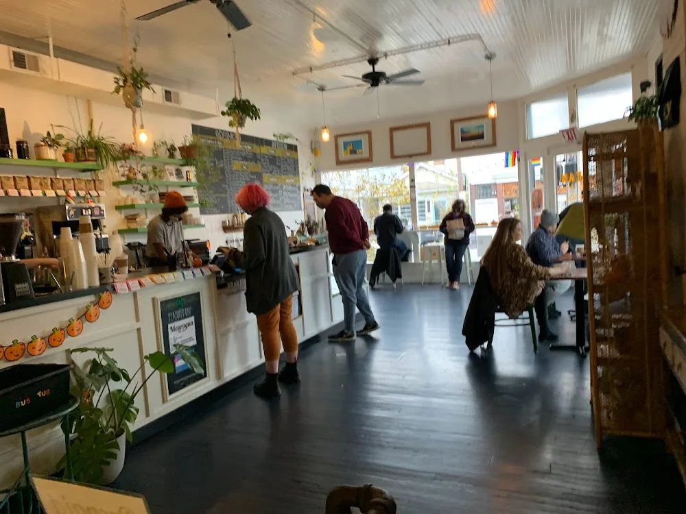 busy coffee shop interior with customers at counter and browsing merchandise displays., bean roastery and cafe, louisville
