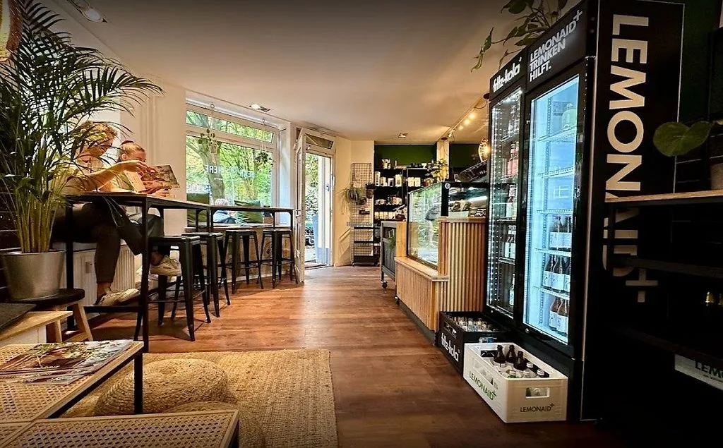 modern café interior with vending machine, seating area, plants, and large windows., bean there, hamburg