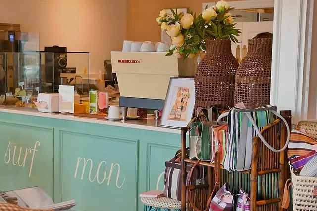 turquoise surf shop counter with flowers, products, and woven storage baskets displayed., beaucoup, newport