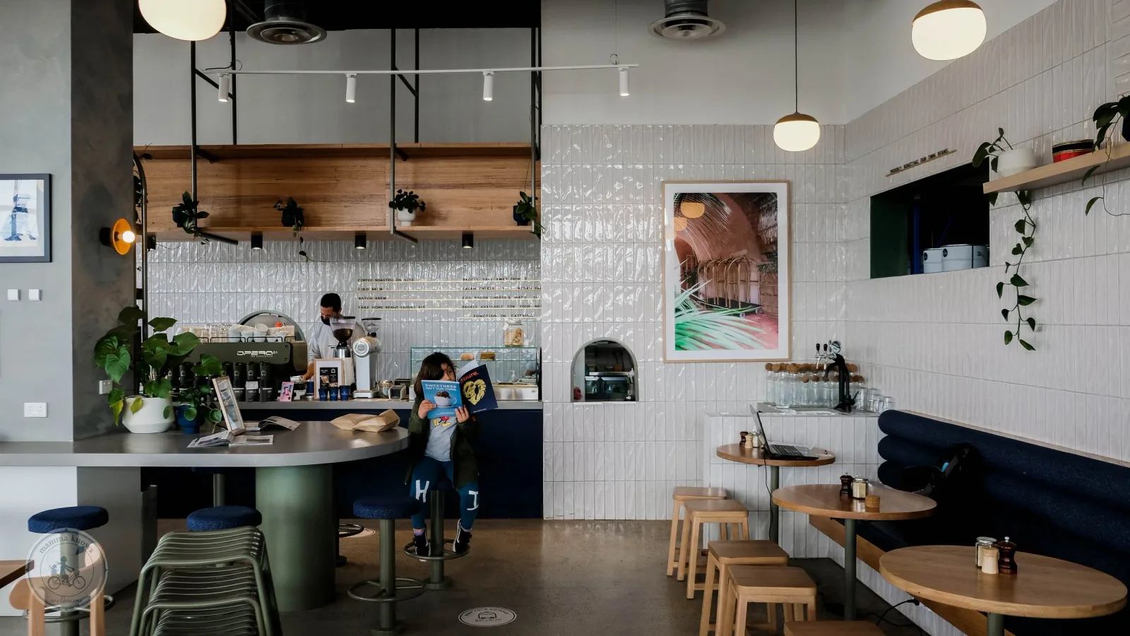modern cafe interior with curved counter, wooden tables, white tile walls, and pendant lighting., bellboy cafe | brunswick ca