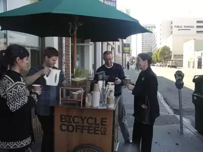 people gathered at a bicycle coffee cart on an urban street corner., bicycle coffee, san francisco
