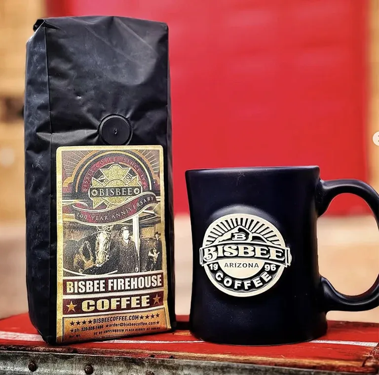 bisbee firehouse coffee bag and black mug on red surface with blurred background., bisbee coffee company, arizona