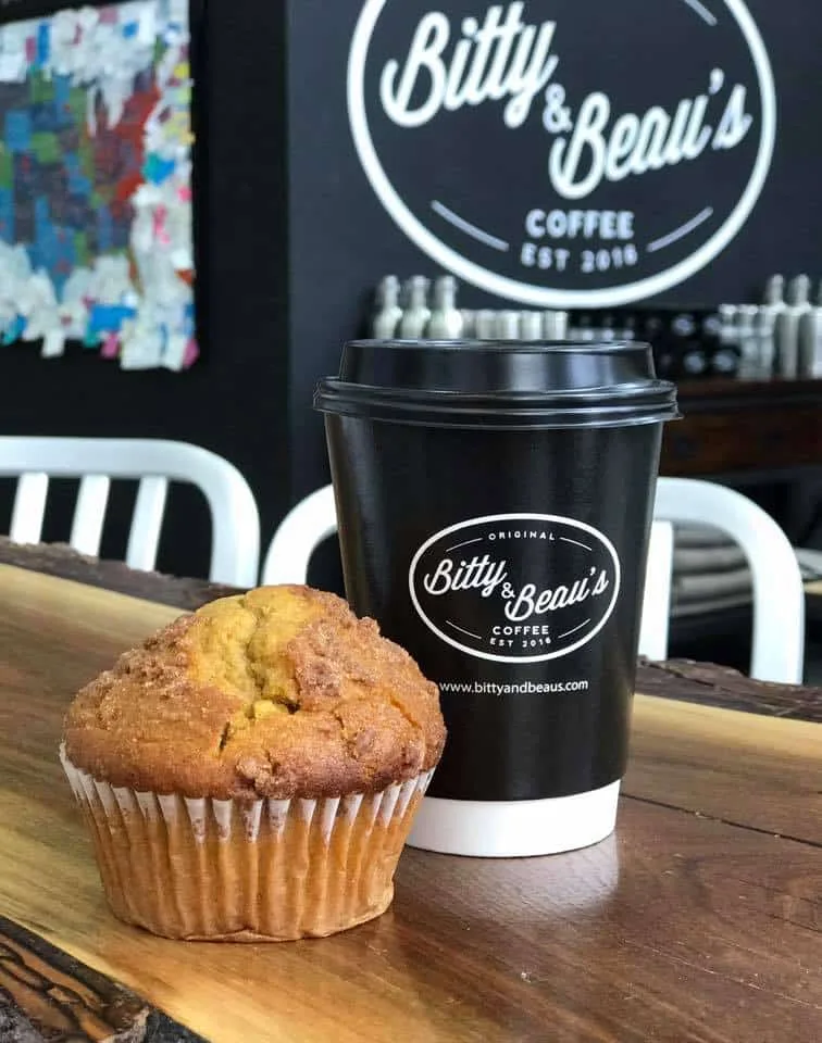 muffin and black coffee cup at bitty & beau's coffee shop counter., bitty and beau’s coffee, charleston