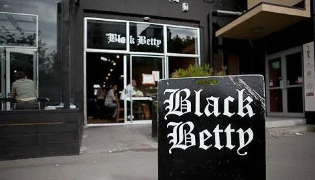 black betty storefront with signage on street-level entrance and sidewalk sign., black betty cafe, christchurch