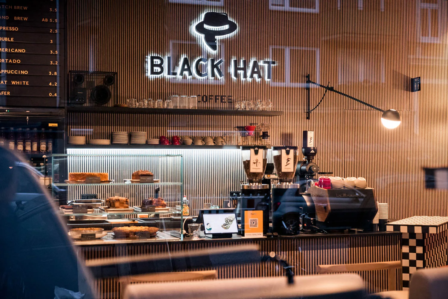 black hat coffee shop counter with espresso machine and neon signage displayed., black hat coffee - specialty espresso bar, h