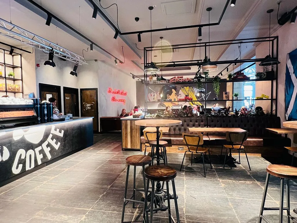 modern coffee shop interior with counter, seating, neon signage, and industrial lighting fixtures., black sheep coffee, aberd