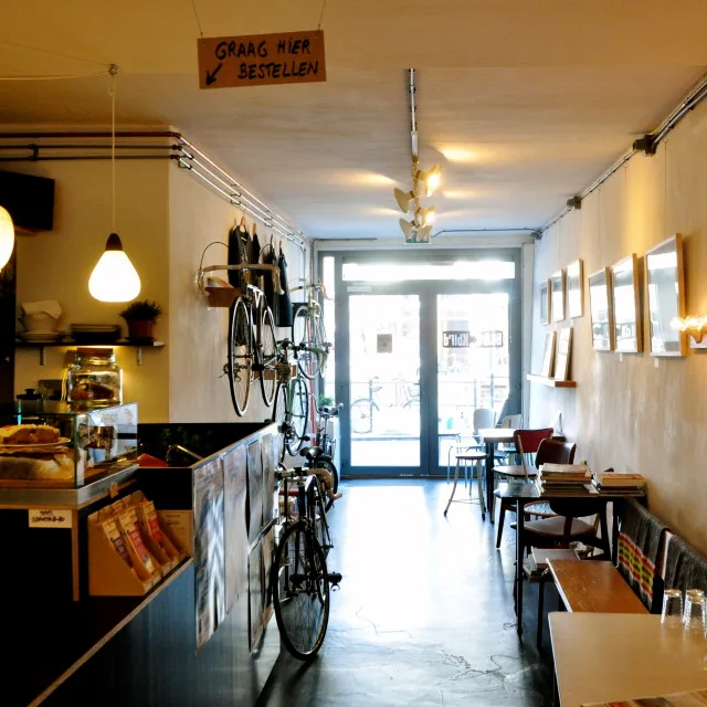 cozy café interior with bikes, counter seating, and warm lighting throughout., blackbird coffee & vintage, utrecht