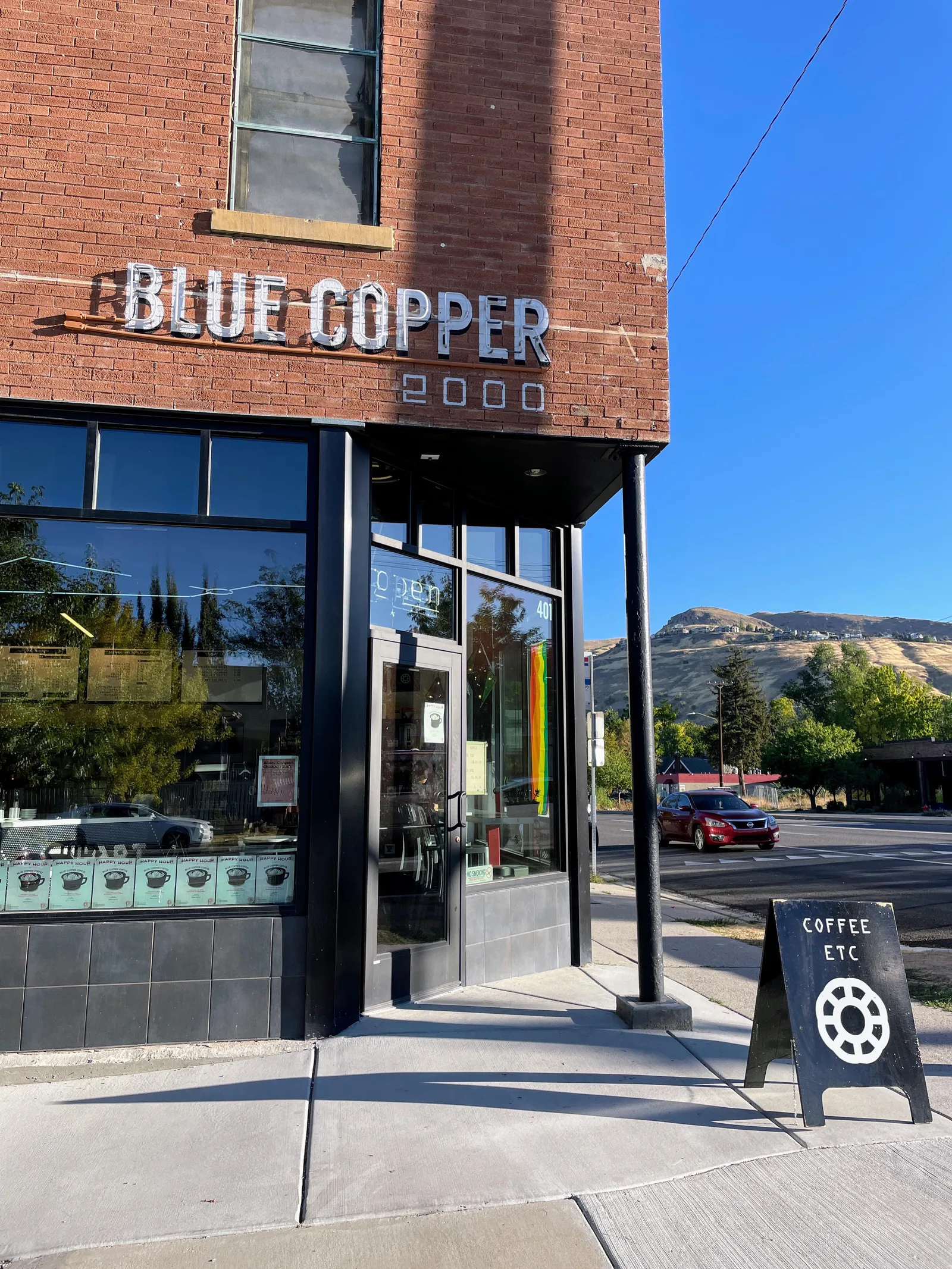 blue copper 2000 coffee shop storefront with brick building and hillside view., blue copper coffee, salt lake city