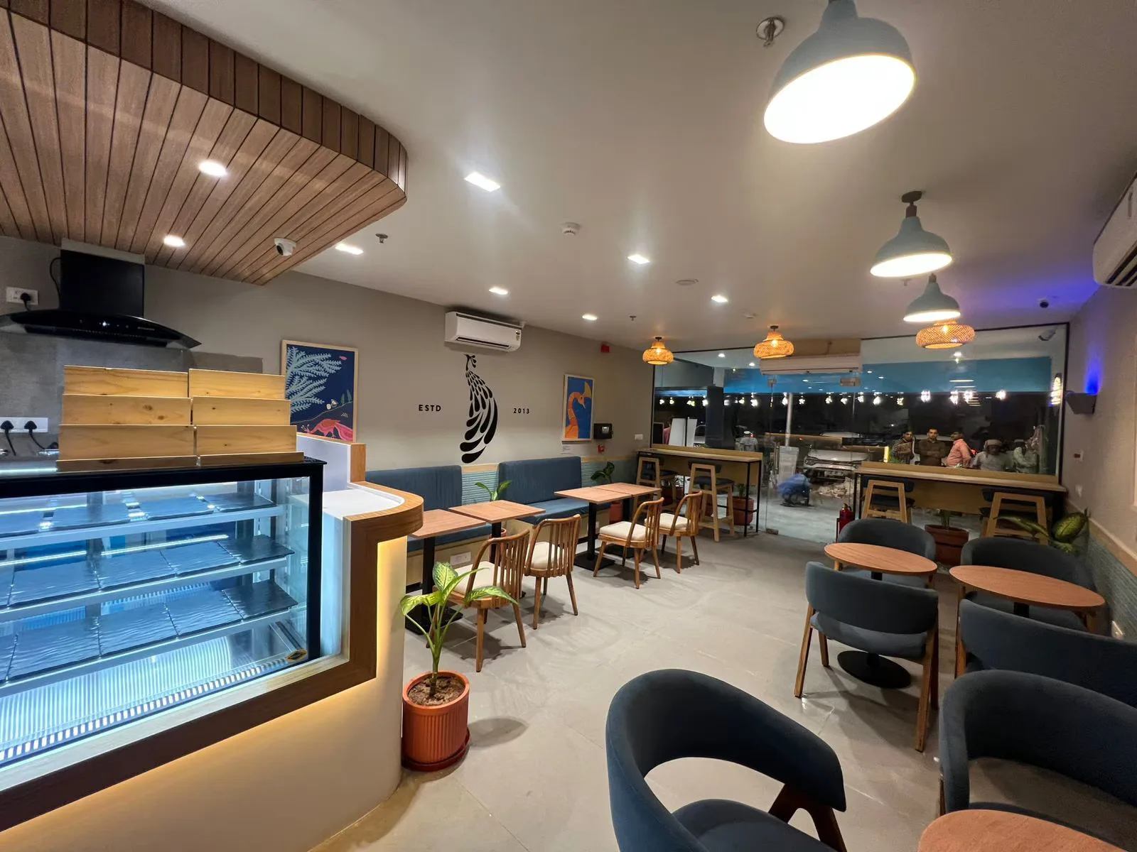 modern café interior with display case, wooden tables, and pendant lighting., blue tokai coffee roasters | chandigarh 35c, ch
