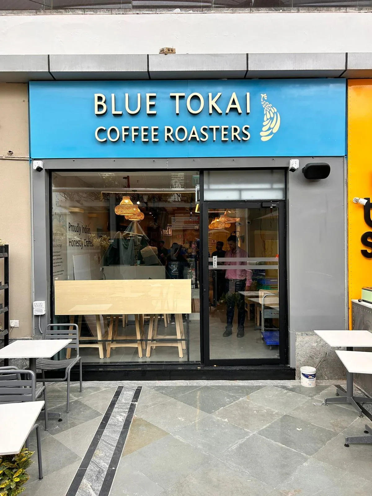 blue tokai coffee roasters storefront with banana logo and outdoor seating area., blue tokai coffee roasters | crossword gurg