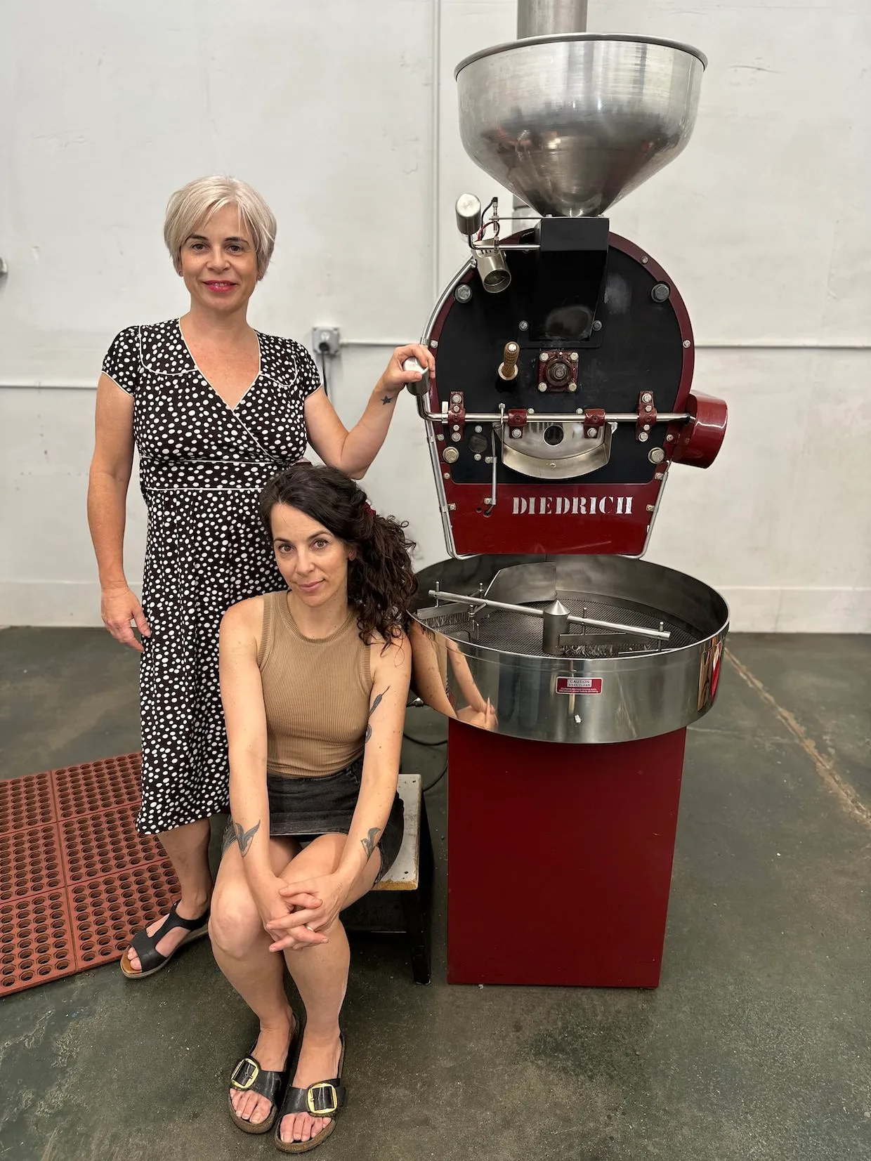 two women posing with a diedrich commercial coffee roaster machine., bluebell coffee usa, grass valley
