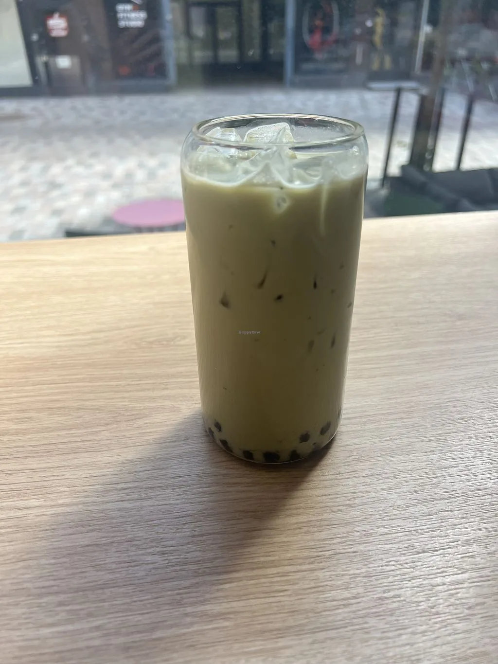 iced milk tea with tapioca pearls in a tall glass on wooden table., bokachá, helsinki