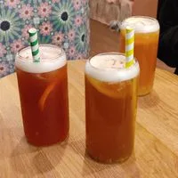 three glasses of iced tea with varying amber hues and foam tops on wooden surface., bokachá, helsinki