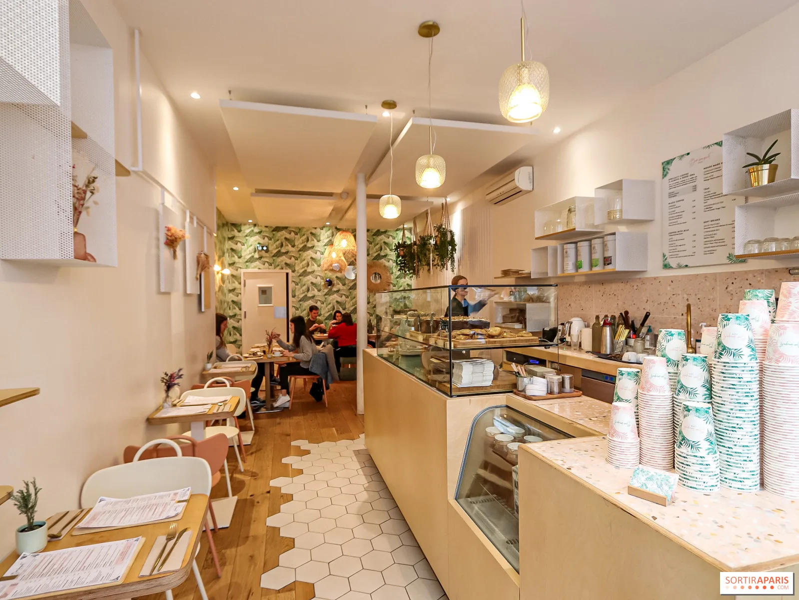 modern café interior with counter, seating area, plants, and pendant lighting fixtures., bon bouquet café, paris